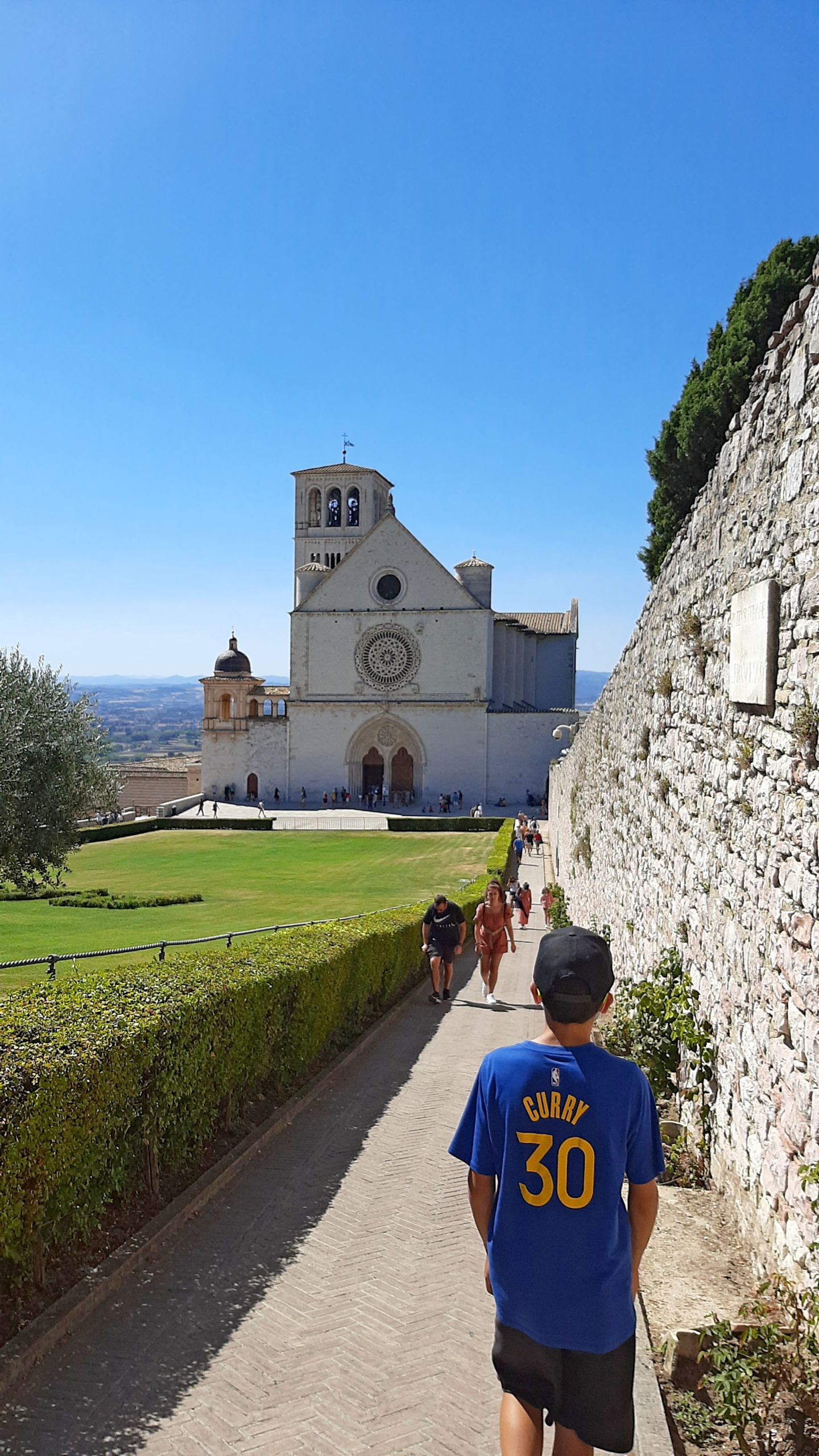 Bambino vicino al prato di fronte alla Basilica di Assisi, vacanze in famiglia "Girolibero"